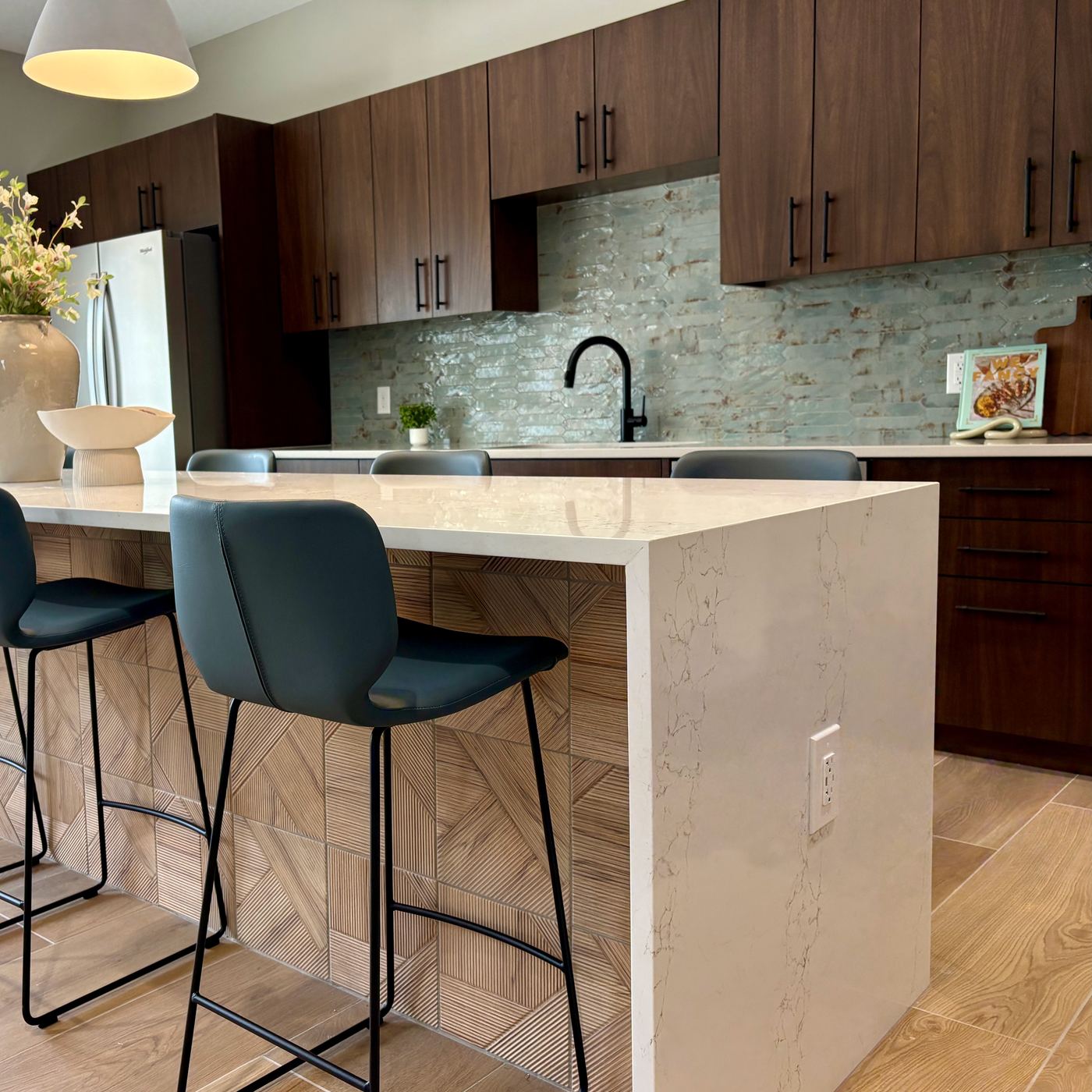 Finished kitchen with dark wood cabinetry, island seating, and tile backsplash